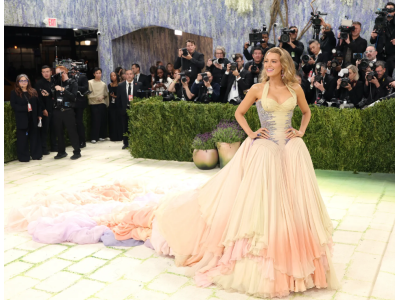 Blake Lively mirdz Met Gala 2026 ar arhīva Versace kleitu un dramatisku šlepi saullēkta un saulrieta krāsās.